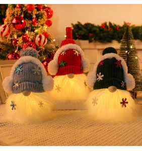 Close-up of glowing LED Christmas gnomes with sequin hats in red, green, and blue colors