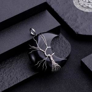 Detailed view of silver tree of life wire-wrapped black crescent moon stone pendant