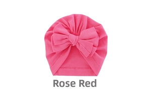 Detailed view of rose red baby turban hat featuring a large soft knit fabric bow