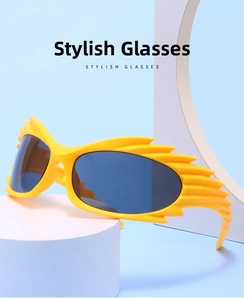 Detail of bright yellow flame-shaped sunglasses with dark blue lenses on geometric props