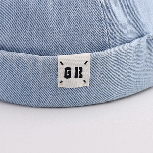Detailed close-up of light blue denim docker hat with GR logo patch and rolled brim edge