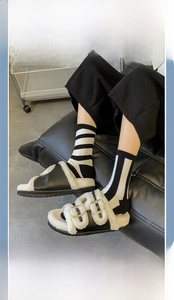 Detailed view of striped cotton mid-calf socks with black leather platform sandals