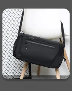 Detail view of water-resistant black nylon crossbody bag featuring multiple zipper pockets