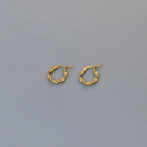 Macro view of golden twisted rope hoop earrings with click-top closure detail