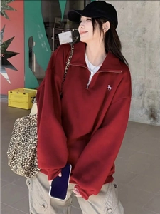 Λεπτομέρεια από μπορντό oversized φούτερ με λευκό κέντημα αλόγου και φερμουάρ στο κολάρο