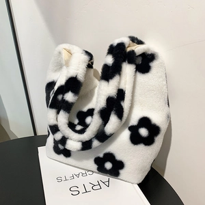 Cute black and white flower plush shoulder bag on a minimalist table setting