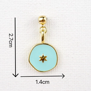 Detail view of light blue enamel star pendant measuring 2.7cm by 1.4cm with gold trim