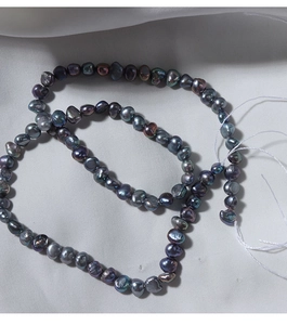 Macro detail of natural 4-5mm baroque pearls with iridescent metallic peacock luster