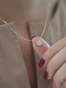 Close-up of 14k gold plated S925 silver necklace with mini sparkling pavé circle pendant
