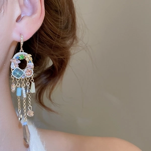 Close-up of vintage crystal tassel earrings with pearls on model in soft lighting