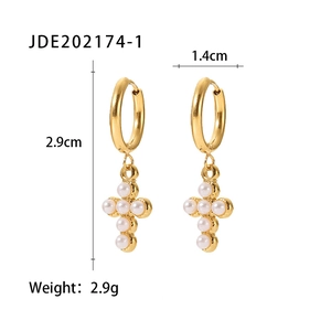 Detail of 18K gold stainless steel hoop earrings with white pearl cross pendant