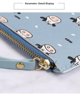 Detail of light blue leather wallet with cow pattern, gold zipper and neat stitching