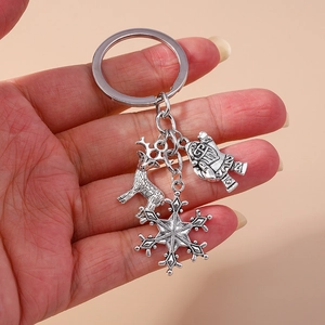 Silver alloy Christmas keychain featuring reindeer, snowflake and snowman charms in hand