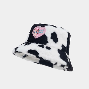 Close-up of pink heart cat patch and fluffy cow print texture on the winter bucket hat