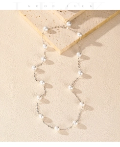 Detailed macro view of an elegant S925 silver necklace with white pearls and metal sequins