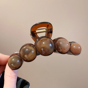Detail of tortoise shell resin hair claw clip with gradient spherical design and metal spring