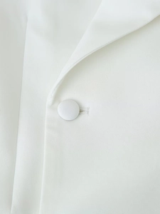 Vue macro du revers de blazer blanc et boutons en tissu avec texture sergée fine