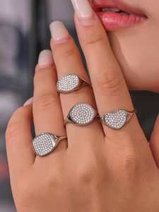 Nahaufnahme von stapelbaren silbernen geometrischen Ringen mit Zirkonia an der Hand
