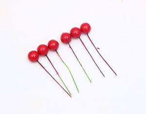 Close-up of artificial red berries with stems for Christmas floral arrangements and DIY