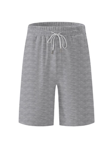 Detail of gray corduroy men's shorts showing textured knit fabric and white drawstring