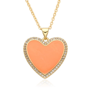 Close-up of golden necklace with orange enamel heart pendant and white zircon inlay