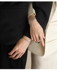 Close-up of couples wearing minimalist mistletoe vine bracelets with zircon accents