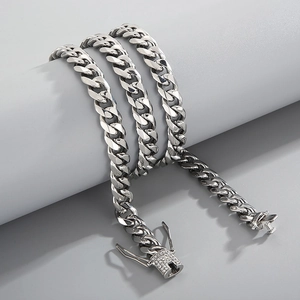 Close-up of a silver Cuban link chain with a sparkling diamond-set clasp on a gray stand