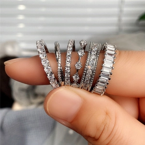 Nahaufnahme von sechs silbernen Ringen mit Baguette- und Rundschliff-Zirkonia-Steinen