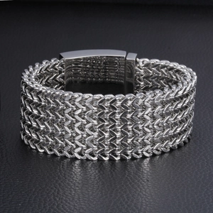 Detail of silver woven mesh stainless steel bracelet with fold-over clasp on black leather