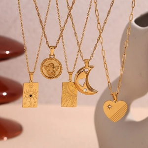 Detail of 18K gold plated stainless steel necklaces with eye, sun, and heart pendants