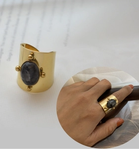 Detailed view of wide 18K gold plated ring with a central oval black stone inlay