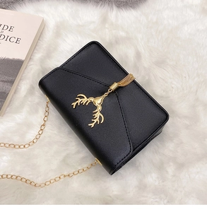 Close-up of black PU leather crossbody bag with golden deer head and chain on white rug