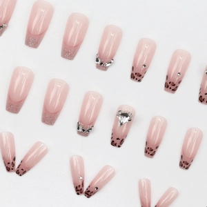 Sparkling pink press-on nails with heart diamonds and leopard prints on white background