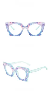 Macro view of purple star-patterned cat-eye frame glasses with glitter blue temples