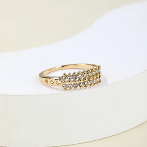 Detailed close-up of gold titanium ring with double rows of zircons and side heart cutouts