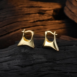 Polished golden geometric trapezoid hoop earrings for women on a dark wood background