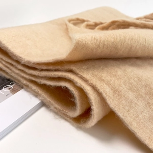 Close-up of soft beige mohair scarf showing premium knit texture and warm material