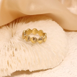 Bague coquillage vintage en acier plaqué or 18 carats présentée sur corail blanc