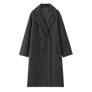 Detail of dark grey double-breasted wool coat featuring textured fabric and classic lapels