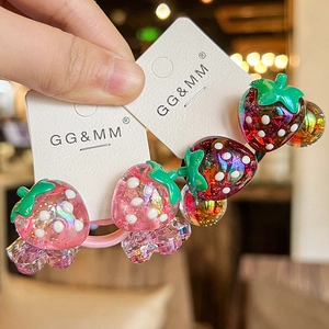 Close-up of sparkling strawberry hair ties with glitter in transparent resin for kids
