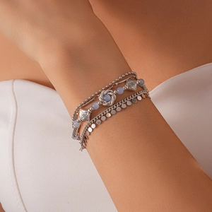 Detail of bohemian layered silver bracelet with grey-blue beads on woman's wrist
