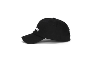 Dettaglio del ricamo bianco baby su un cappellino da baseball in cotone nero
