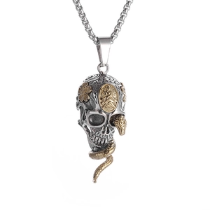 Detailed view of silver skull pendant with a gold snake wrap and floral accents