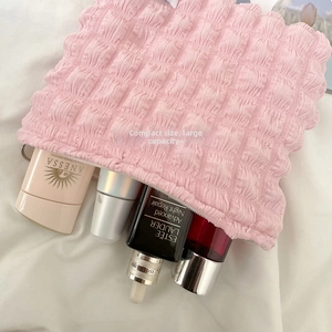 Macro shot of pink bubble textured makeup bag showing large capacity for skincare items