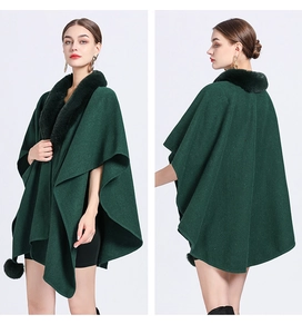 Macro shot of dark green knitted poncho showing plush faux fur collar and hem details