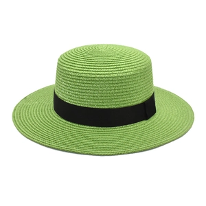 Detail of neon green boater hat featuring woven straw texture and a black ribbon band