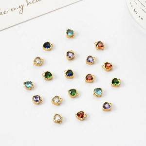 Flat lay of colorful heart-shaped cubic zirconia charms with gold-plated metal settings