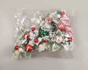 Detailed view of flocked Christmas teardrop swag with red and white festive ornaments