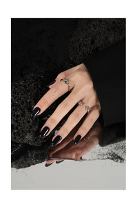 Detailed close-up of knotted S925 silver rings on volcanic rock with mirror reflection