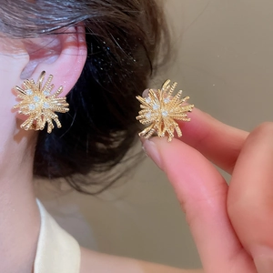 Detailed macro view of 18k gold-plated fireworks earrings with sparkling zircons